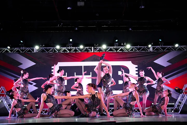 HSD company dancers in sparkling costumes performing together on the competition stage