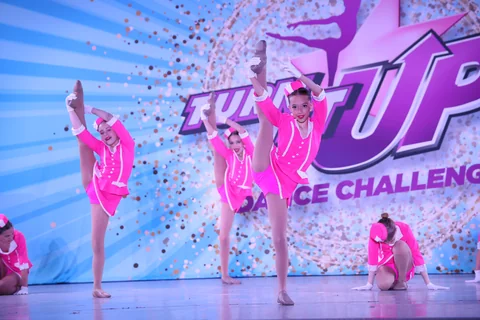Dancers in bright pink costumes performing on stage