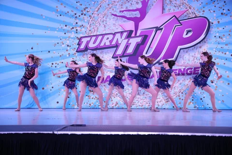 Dancers in blue fringed costumes performing in formation